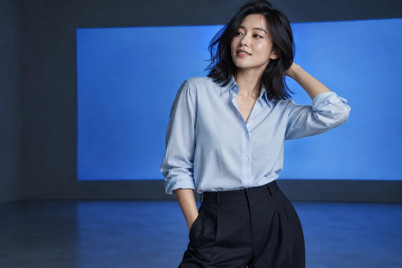 AI 生成的穿搭配图：身着浅蓝衬衫的女性站在蓝色光线的摄影棚中